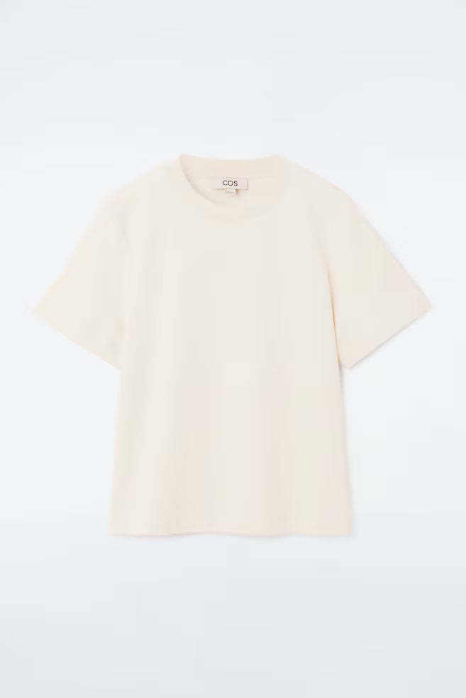 Beige t-shirt with 'cos' branding on a light gray background