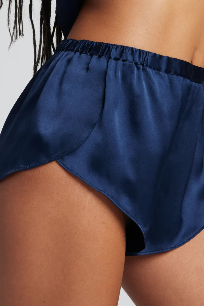 Navy blue satin shorts worn by a person on a plain background