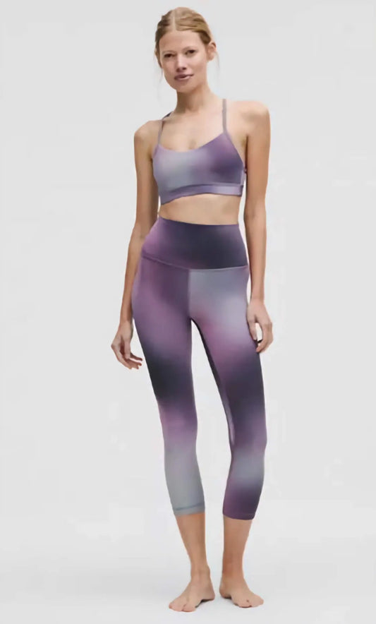 Woman wearing a gradient sports bra and leggings on a white background
