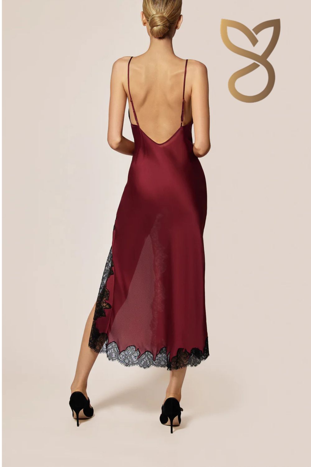 Burgundy slip dress with lace hem on a beige background