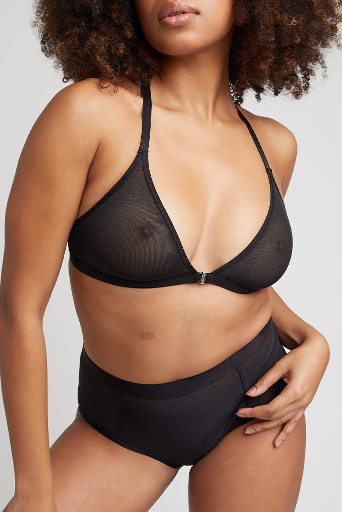 Woman wearing a black bikini set against a neutral background