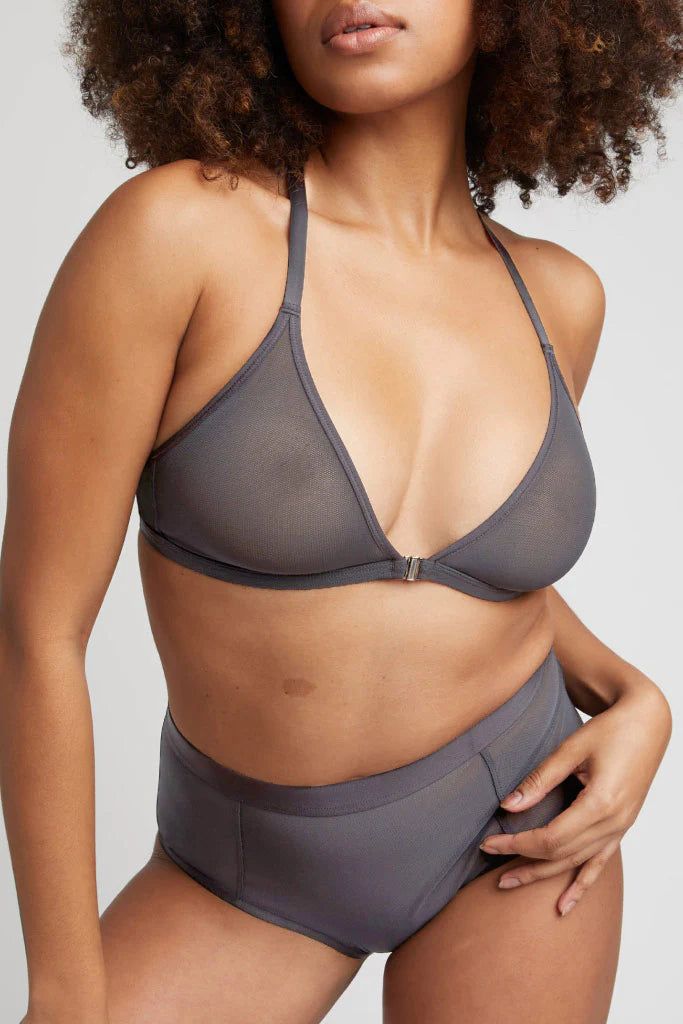 Woman wearing a gray bikini set on a plain background