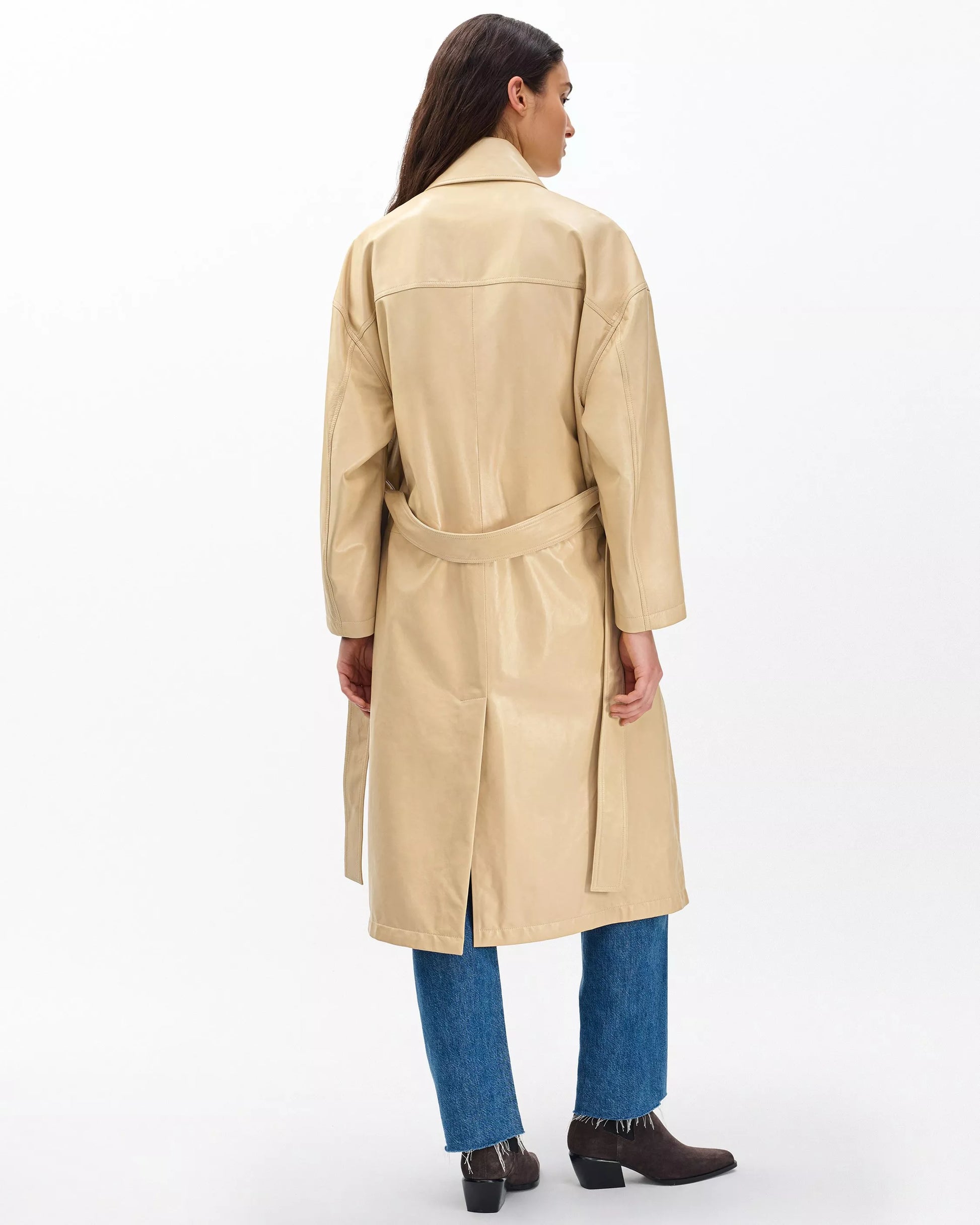 Woman wearing a beige trench coat on a white background