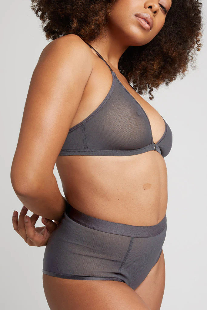 Woman wearing a gray bikini set on a plain background