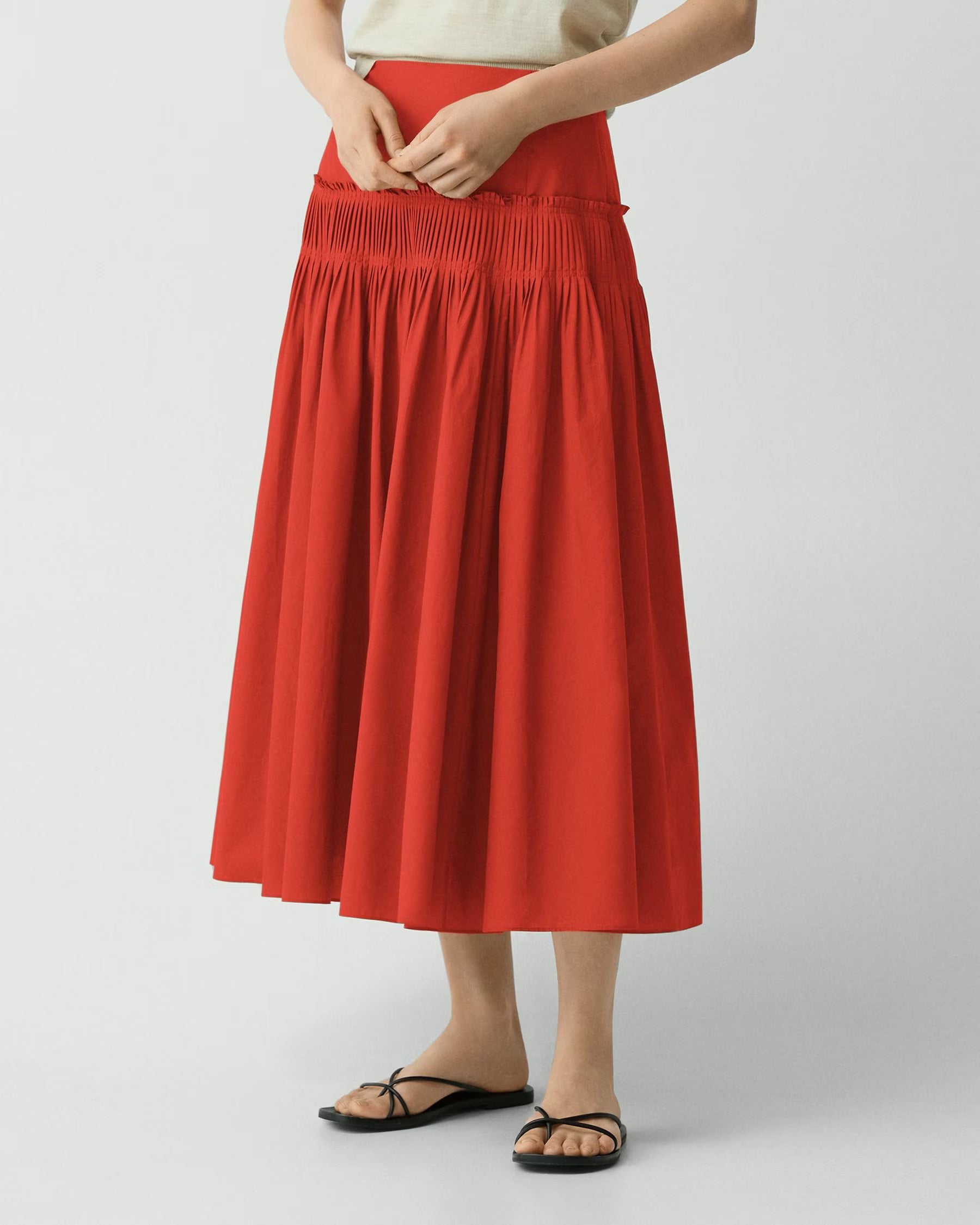 Person wearing a red skirt on a white background