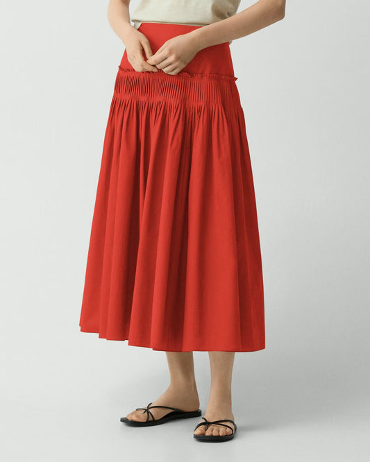 Person wearing a red skirt on a white background
