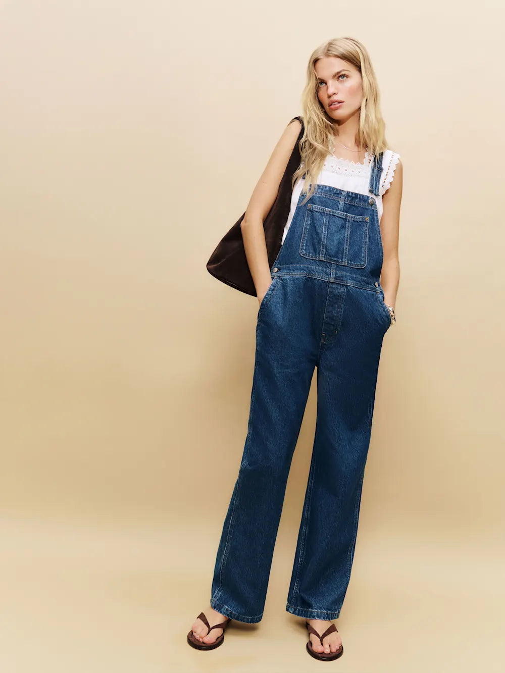 Woman in relaxed-fit Arlo Denim Overalls standing in a sunlit Hudson Valley apple orchard at golden hour, embodying sovereign autumn ritual, climate-positive luxury, and archival elegance.