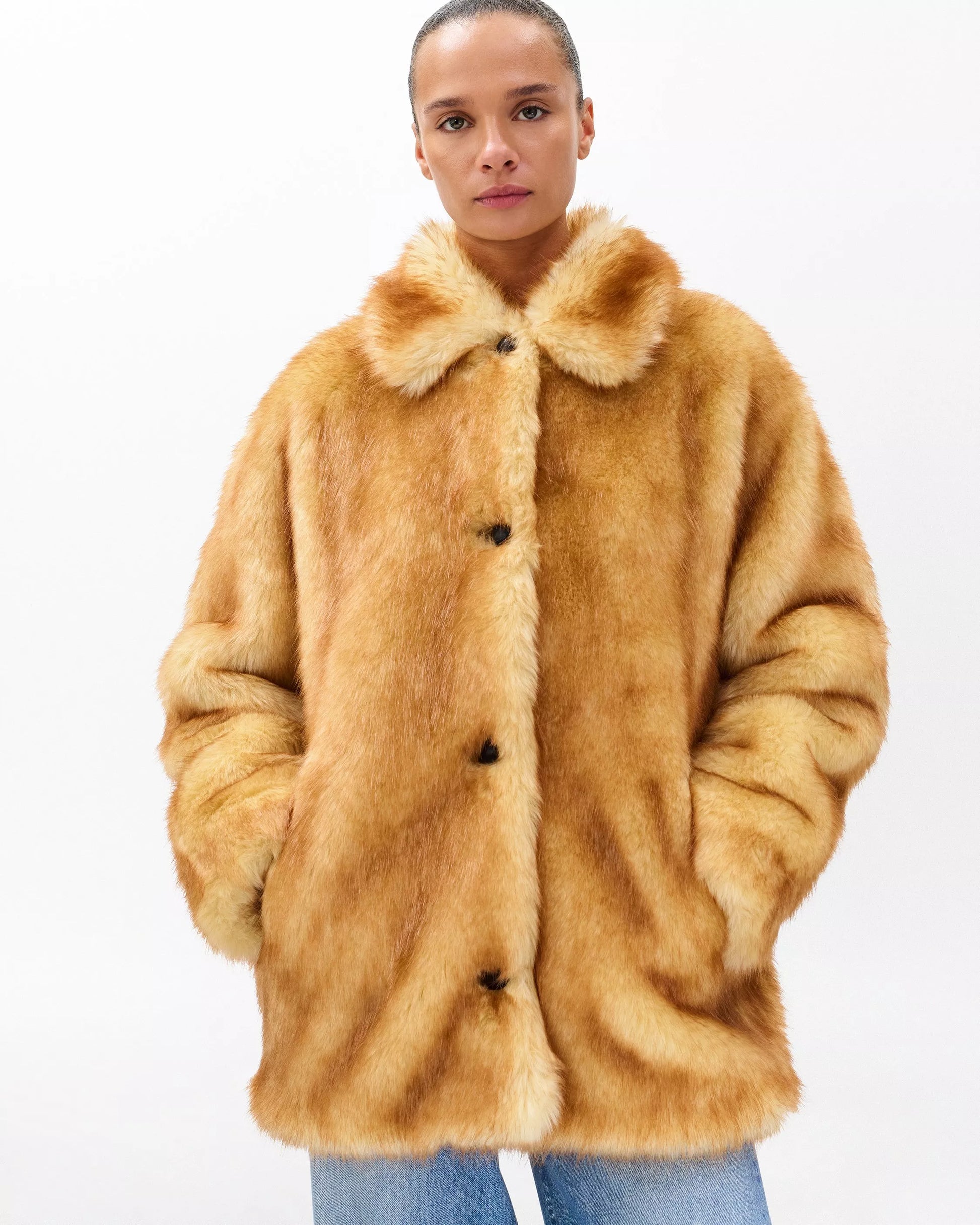 Person wearing a brown faux fur coat on a white background