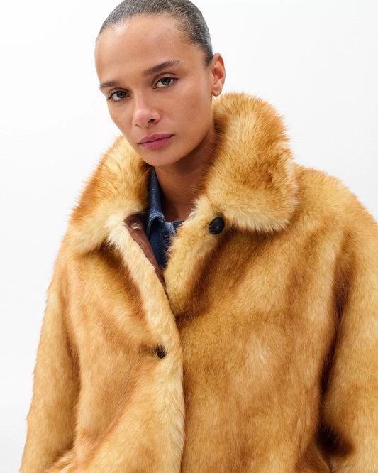 Woman wearing a brown fur coat on a white background