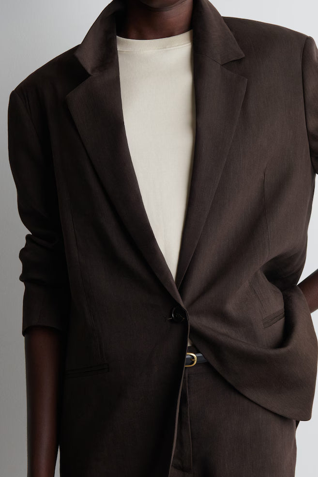 Brown blazer worn by a mannequin against a gray background