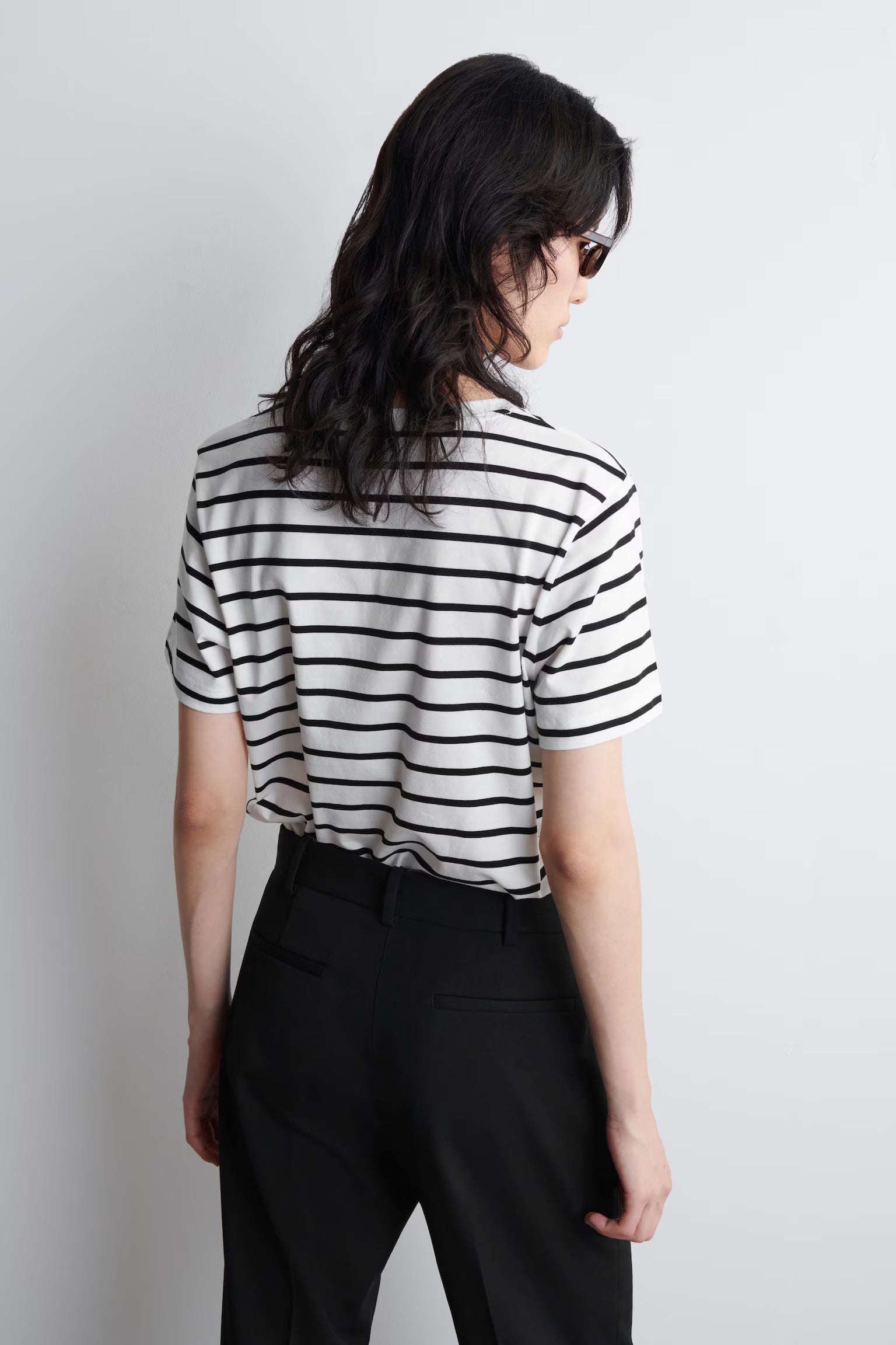 Person wearing a black and white striped shirt against a plain background