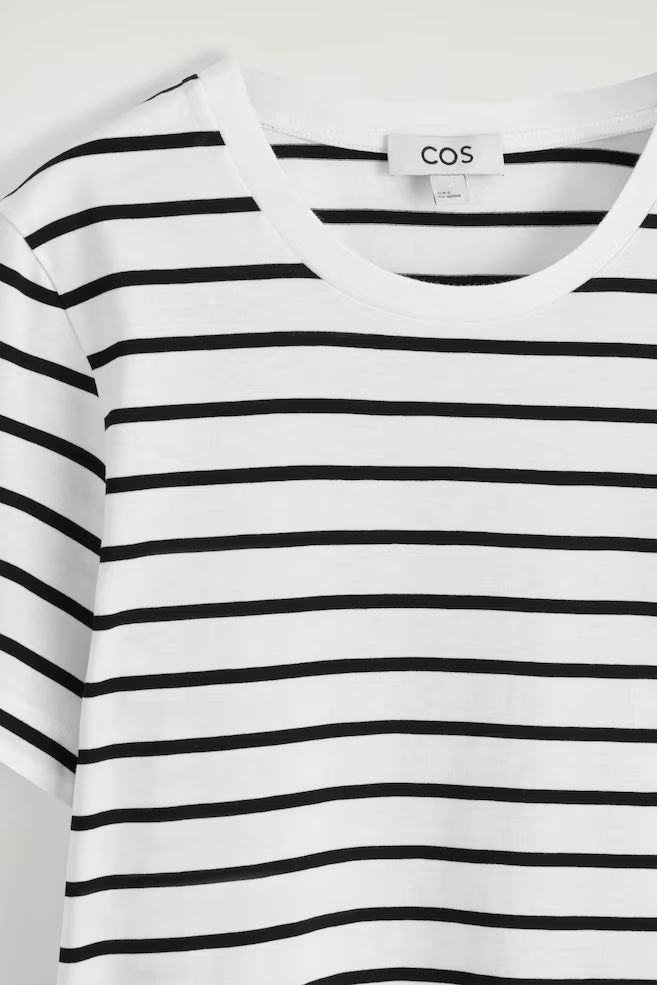 Black and white striped shirt with COS label on a white background