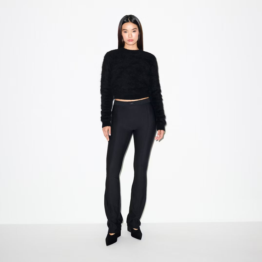 Person wearing a black outfit on a white background