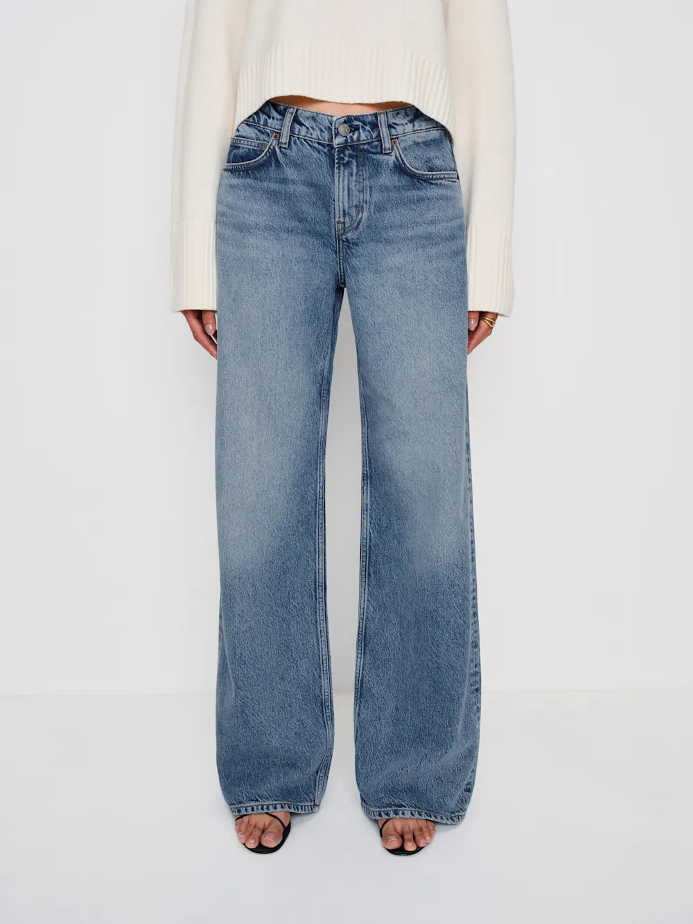 Blue jeans worn by a person on a white background