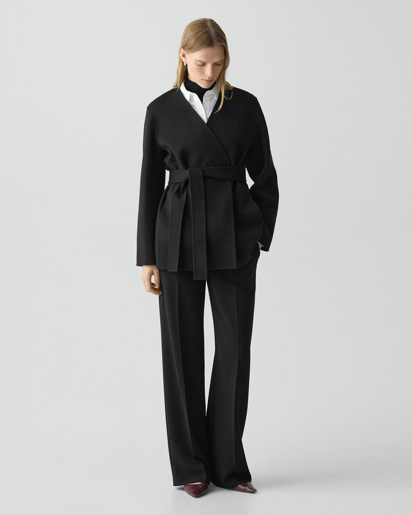 Woman wearing a black suit on a white background