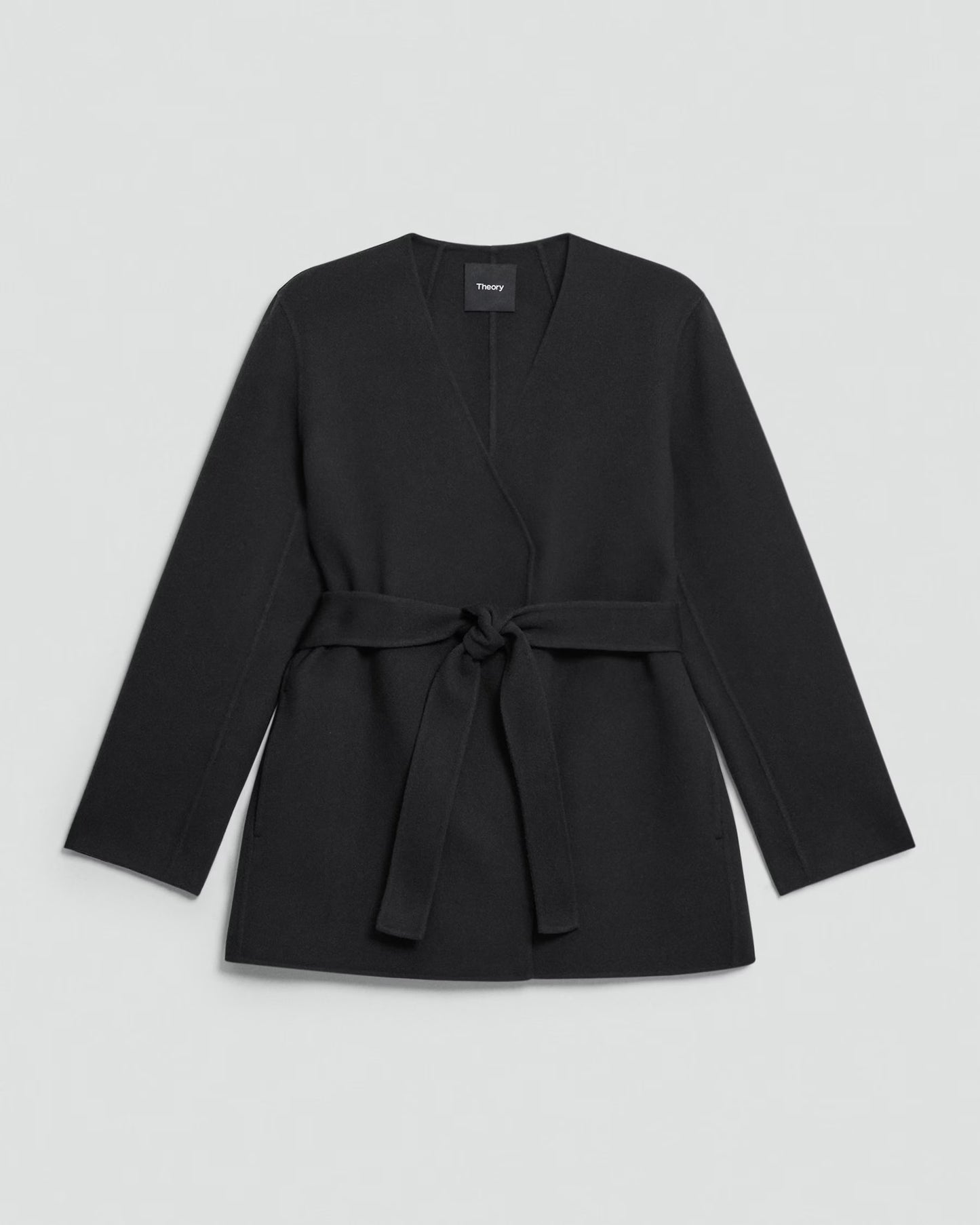 Black belted jacket on a light gray background