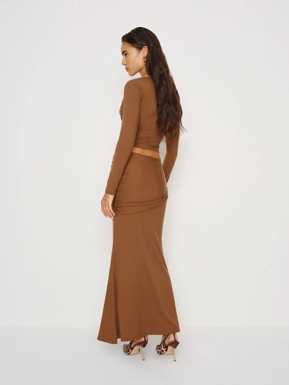 Woman wearing a brown dress against a white background