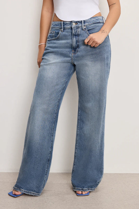 Person wearing blue jeans against a plain background
