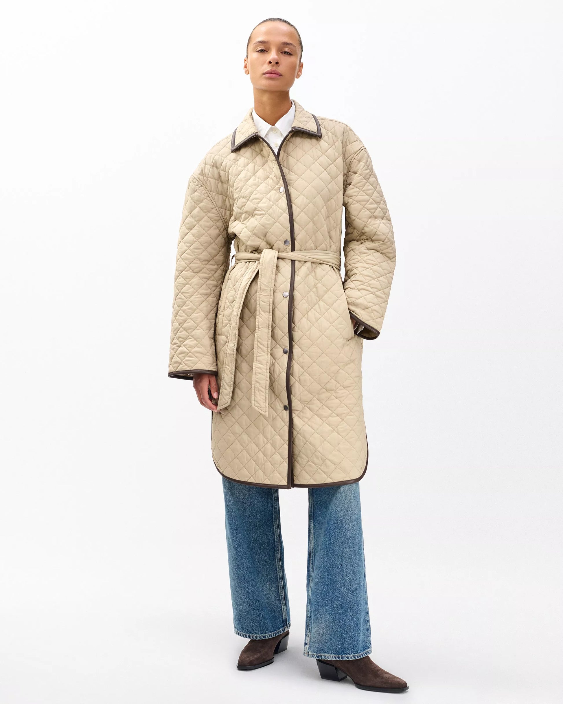 Woman wearing Kelly Quilted Jacket by Lux & Motion | Lightweight nylon jacket with faux leather details | Adjustable waist belt | Foundation 2025 Collection