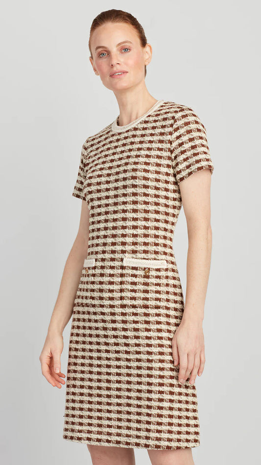 Woman wearing a checkered dress on a plain background