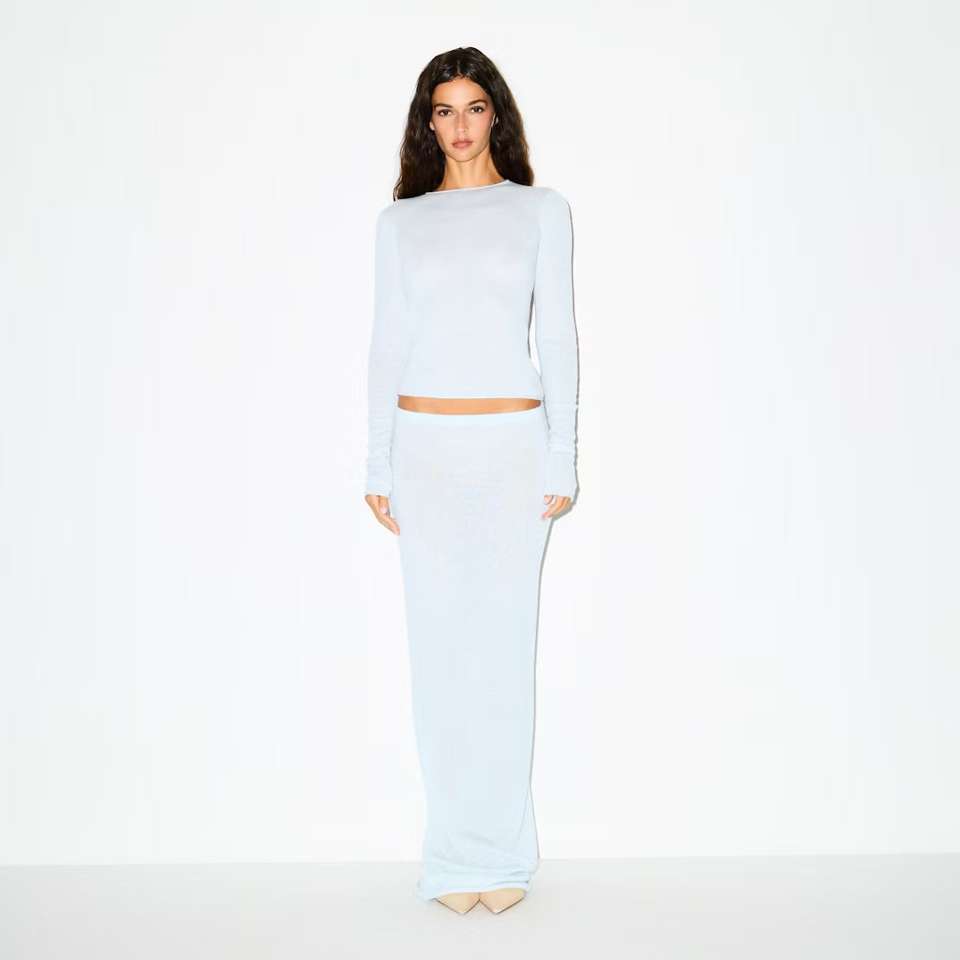 Woman wearing a light blue outfit on a white background