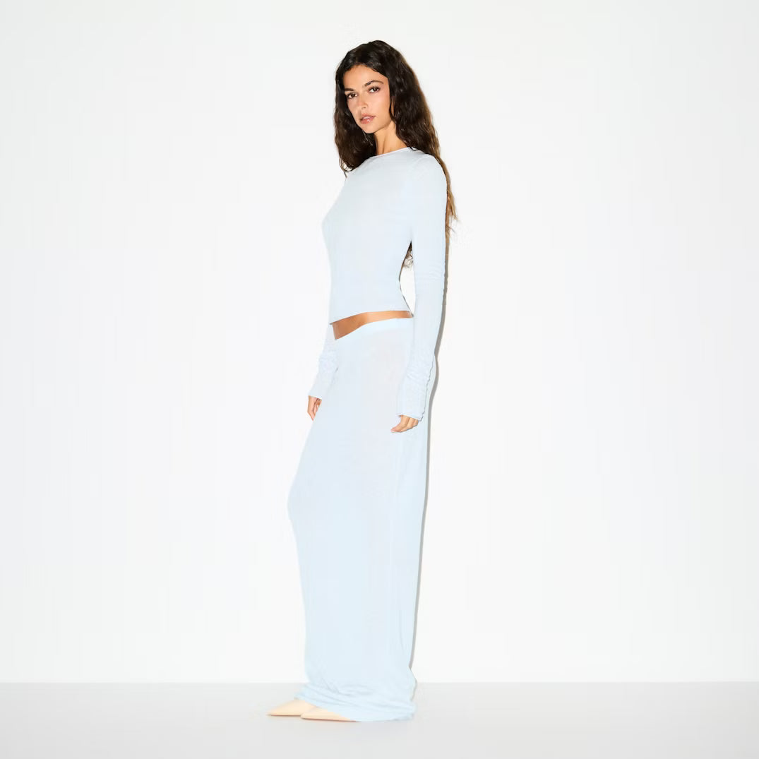 Woman wearing a light blue outfit on a white background
