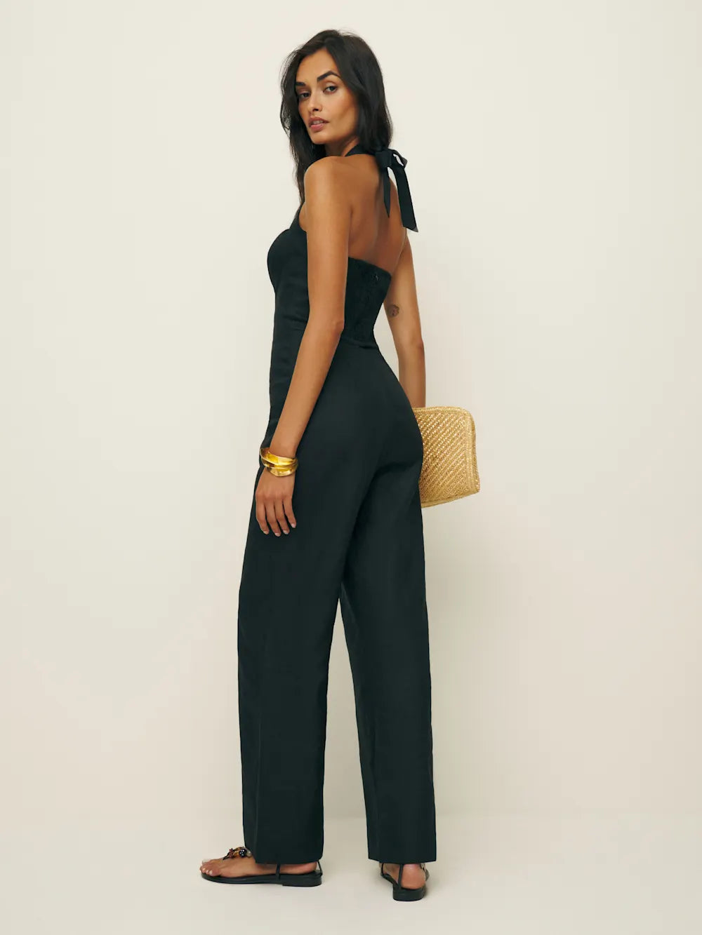Woman wearing a black jumpsuit with a white background