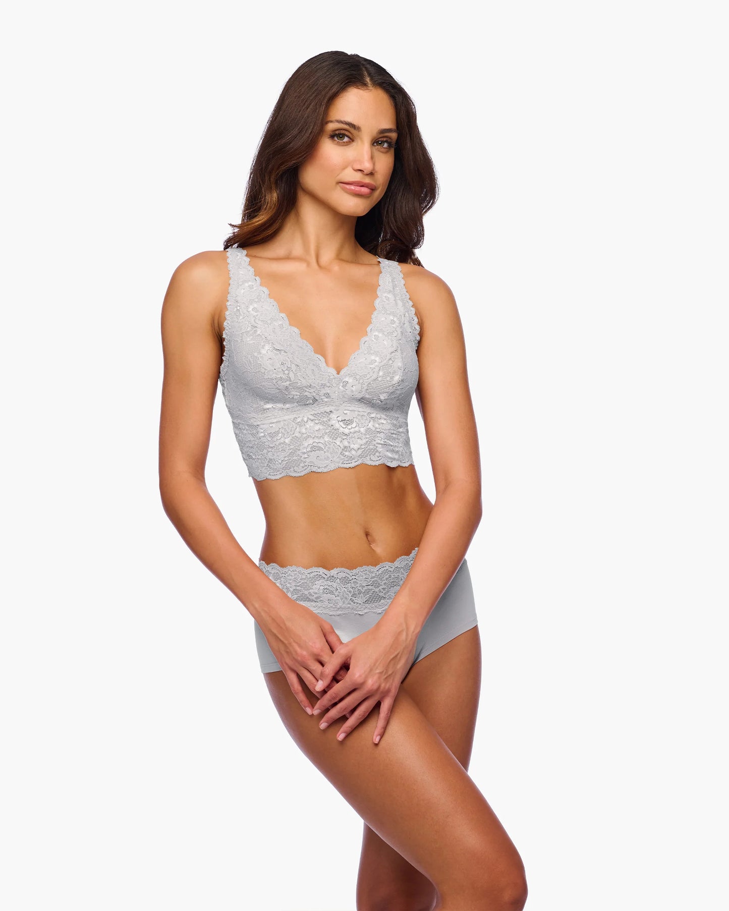 Woman wearing a gray lace bra and panties set on a white background