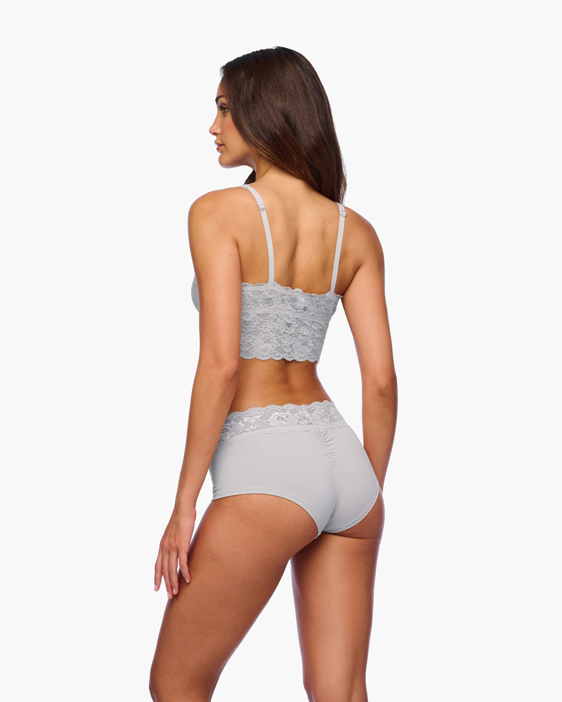 Woman wearing a gray lace lingerie set on a white background