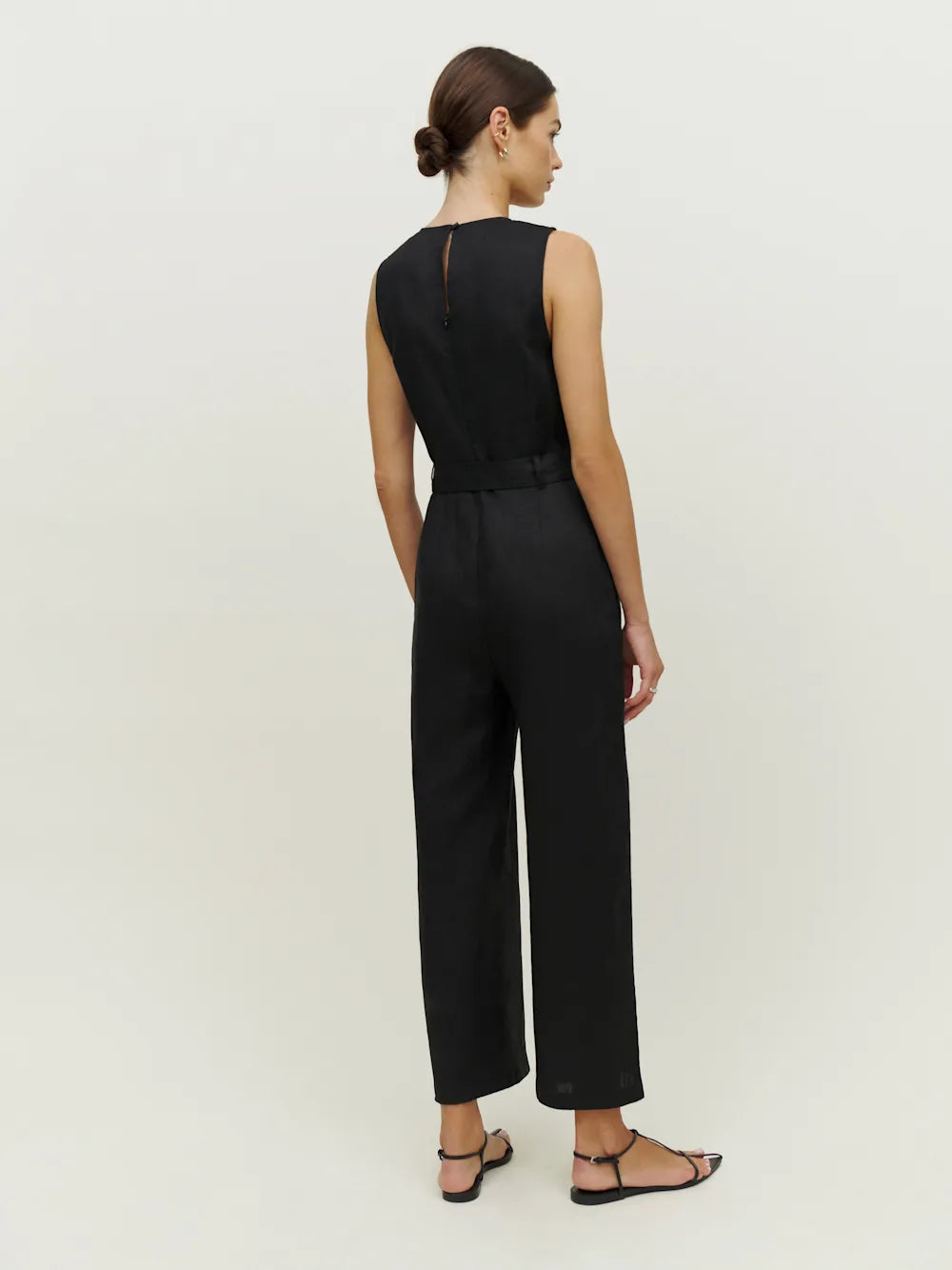 Woman wearing a black sleeveless jumpsuit on a white background