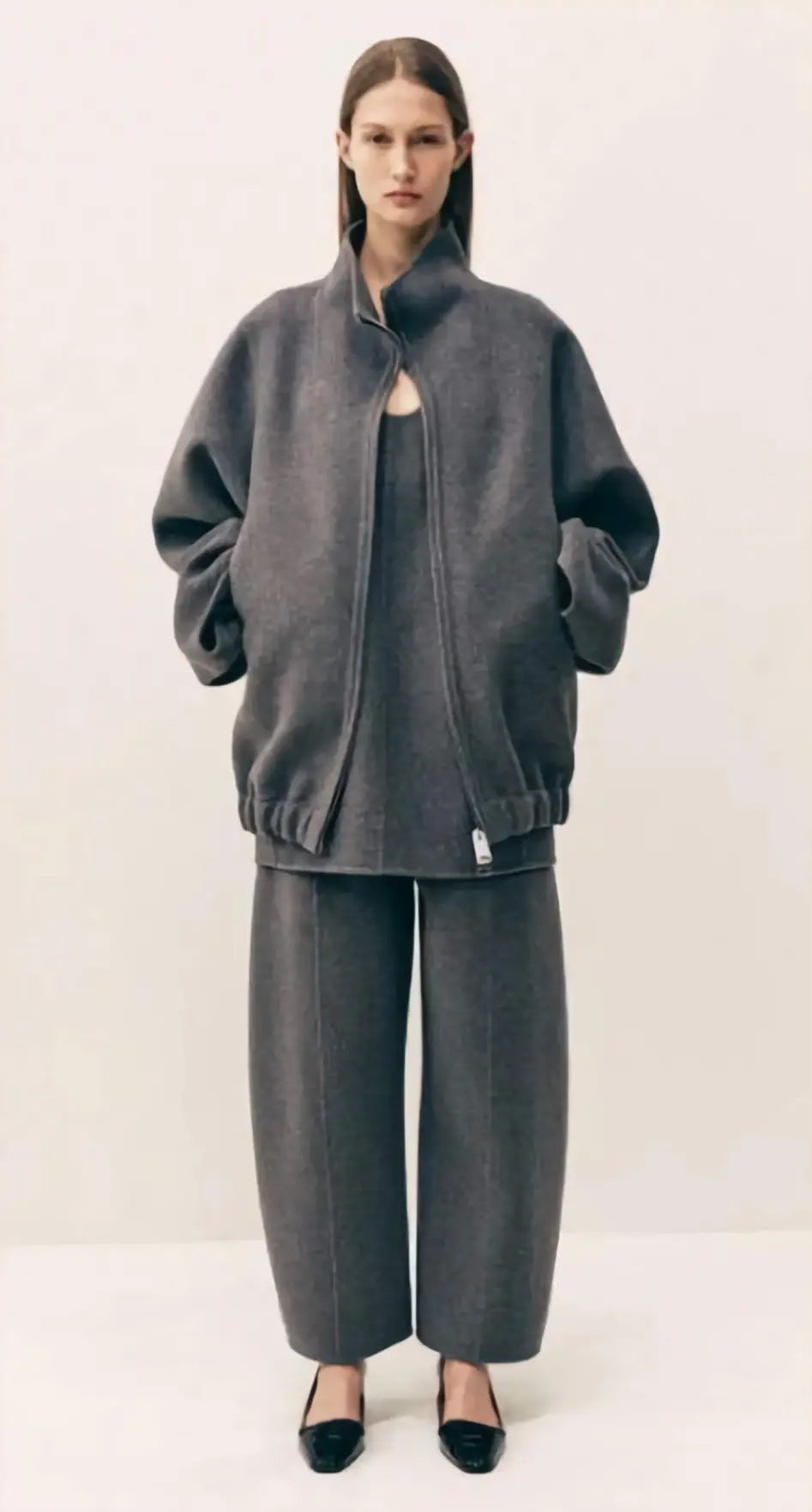 Person wearing a gray outfit on a white background