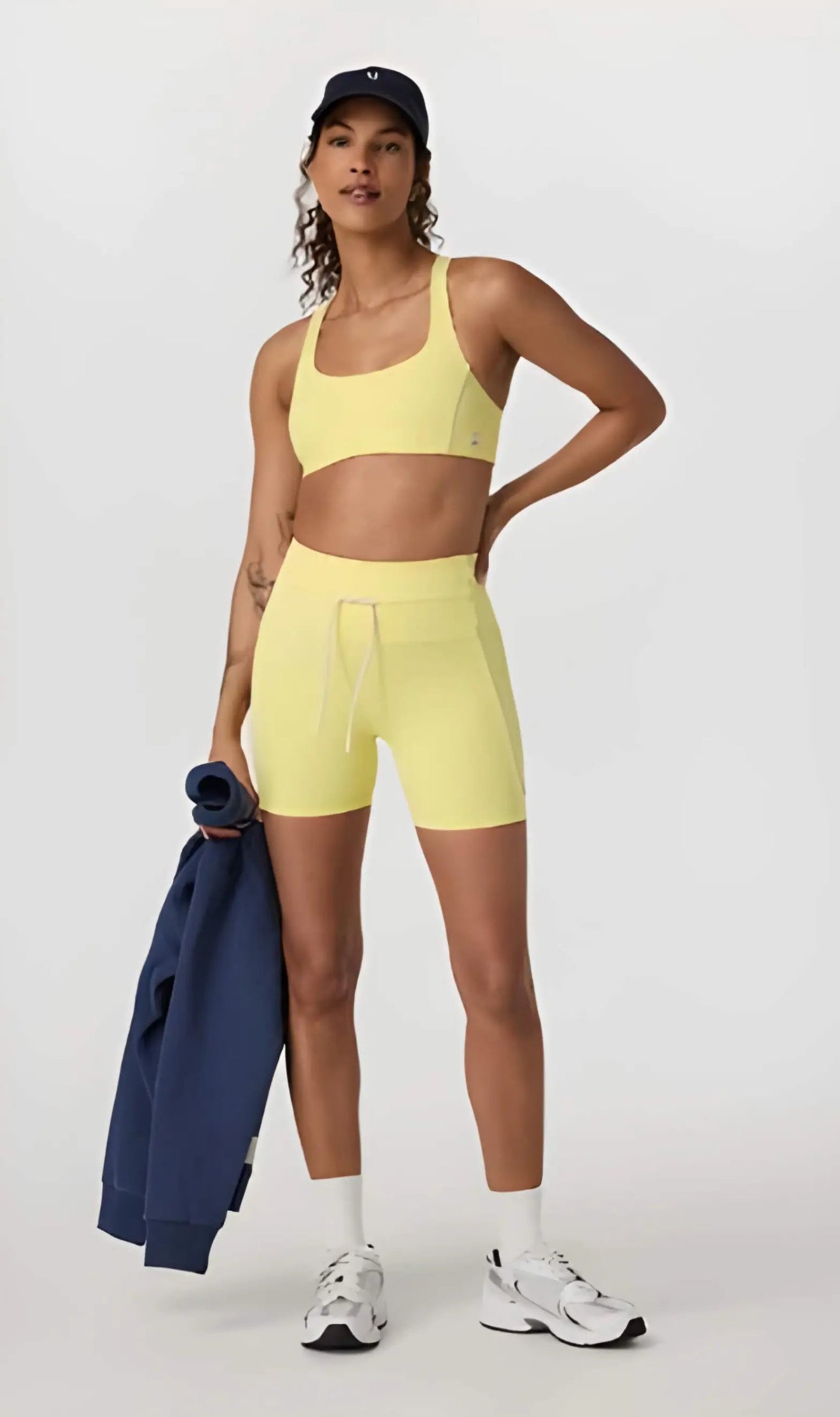 Daily Piped Short 5" in viridian green, showcasing the high-rise waistband and piped detailing on a model in a dynamic pose.