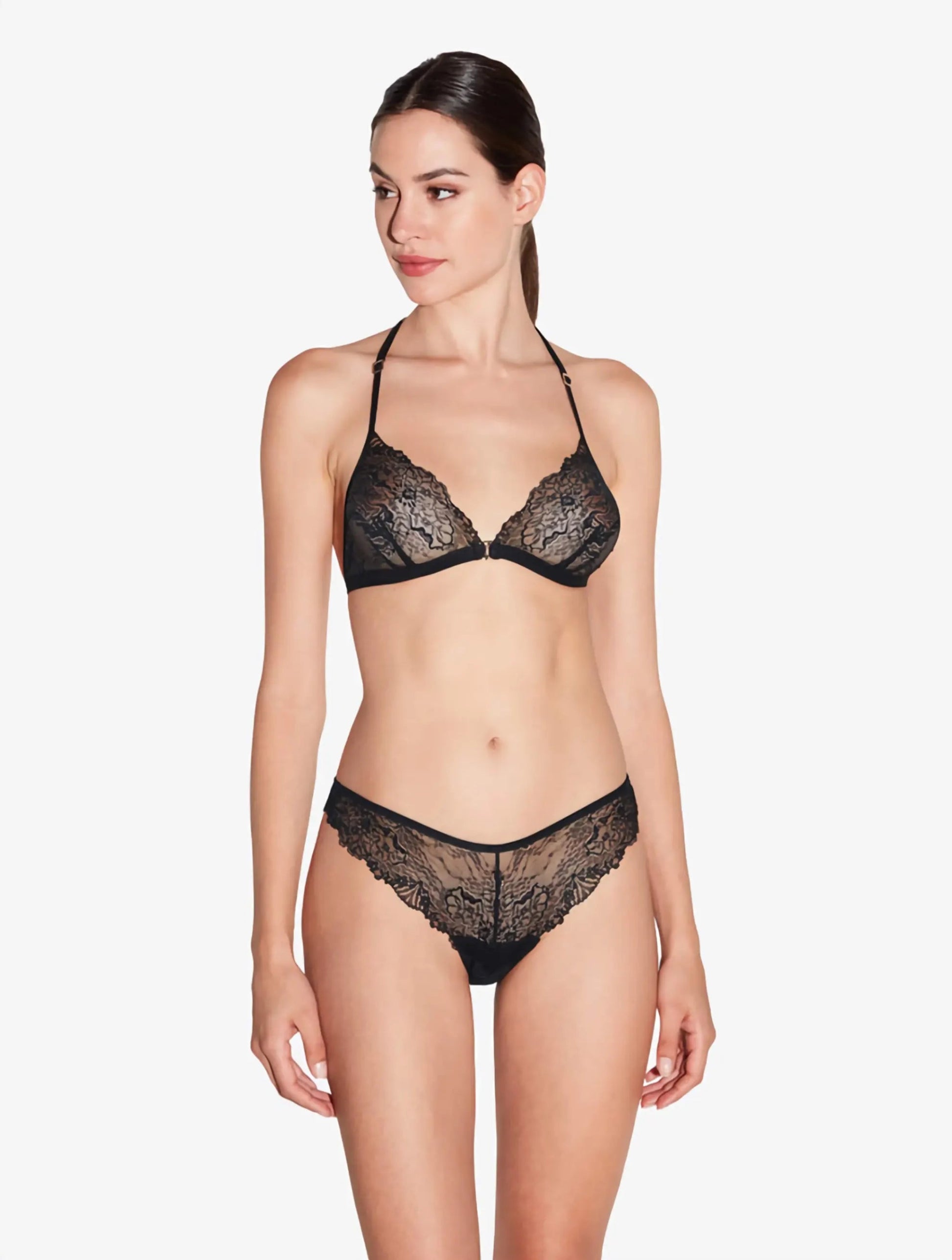 Woman wearing a black lace lingerie set on a white background