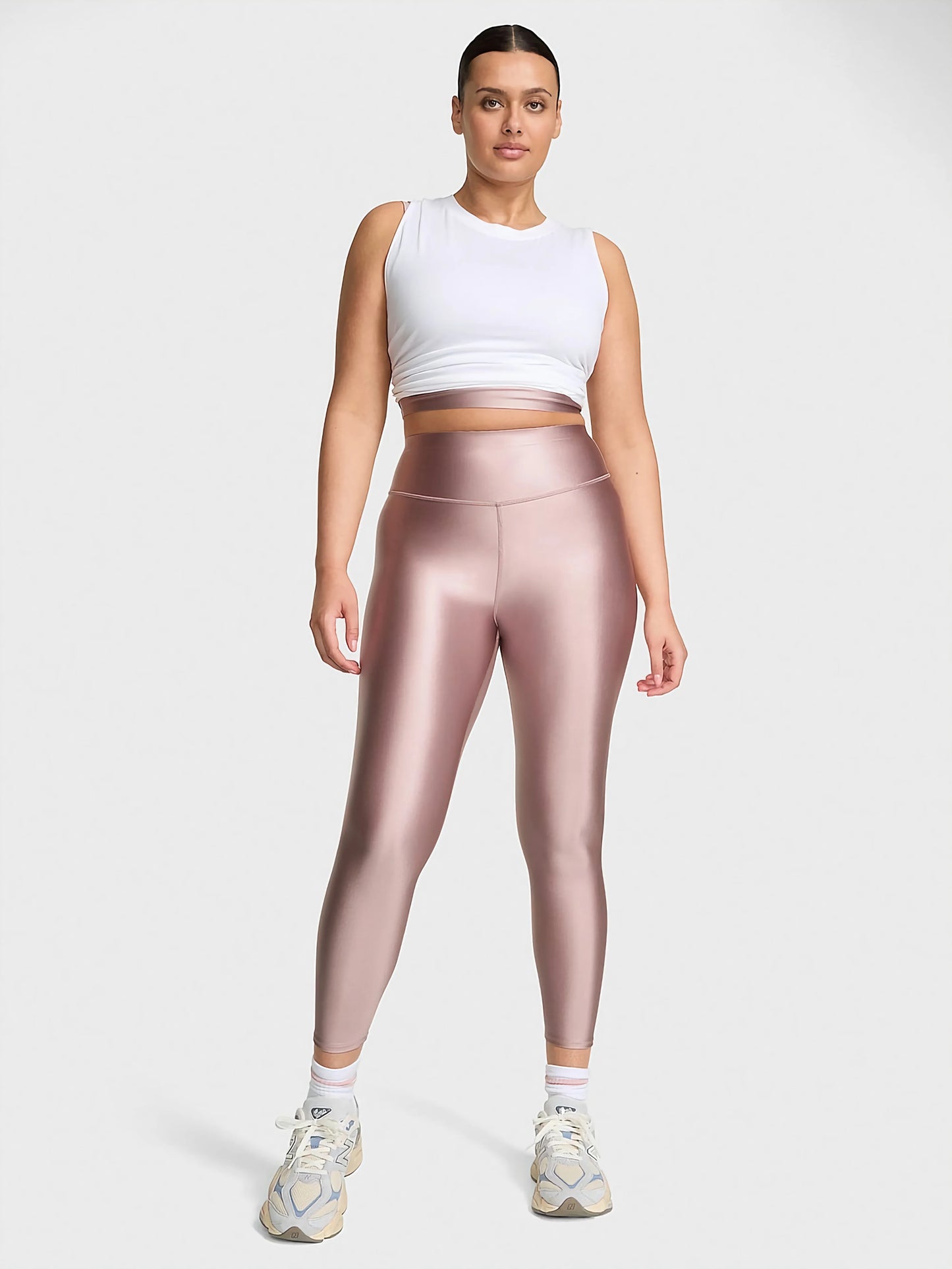 VSX GlossyTech Legging in black, showcasing its high-shine finish and sculpting high-rise silhouette on an active woman