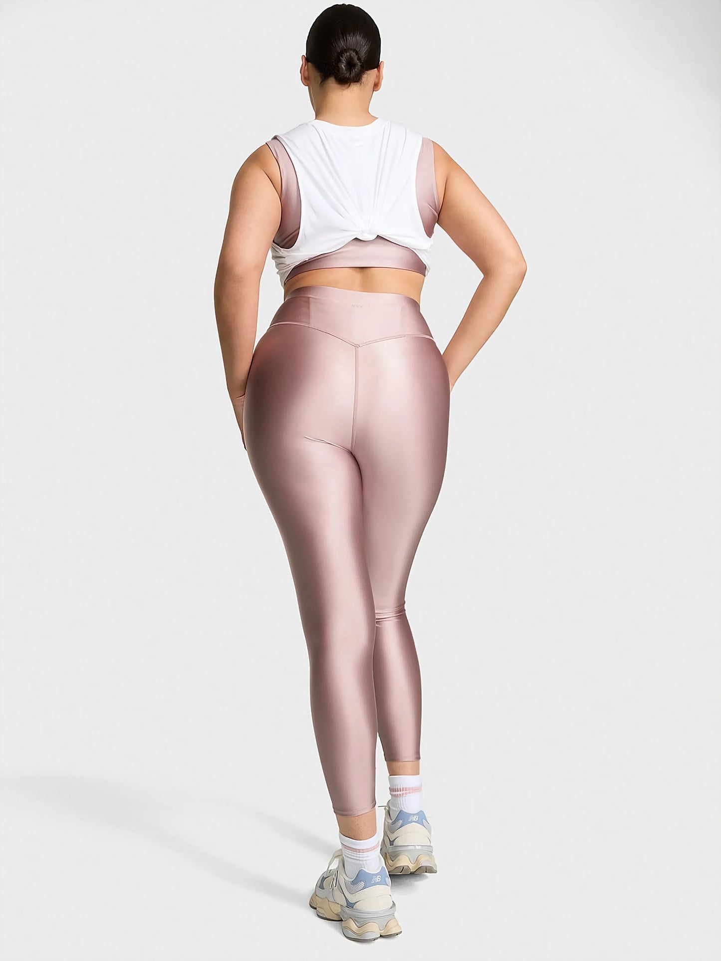 VSX GlossyTech Legging in black, showcasing its high-shine finish and sculpting high-rise silhouette on an active woman