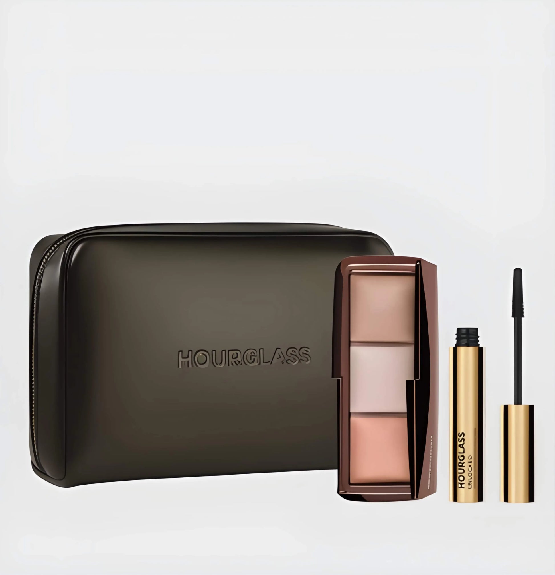 he Hourglass Essentials Set open on a marble surface, showcasing the Ambient Lighting Palette, Unlocked Mascara, and vegan leather bag for a ritual of radiant elegance.