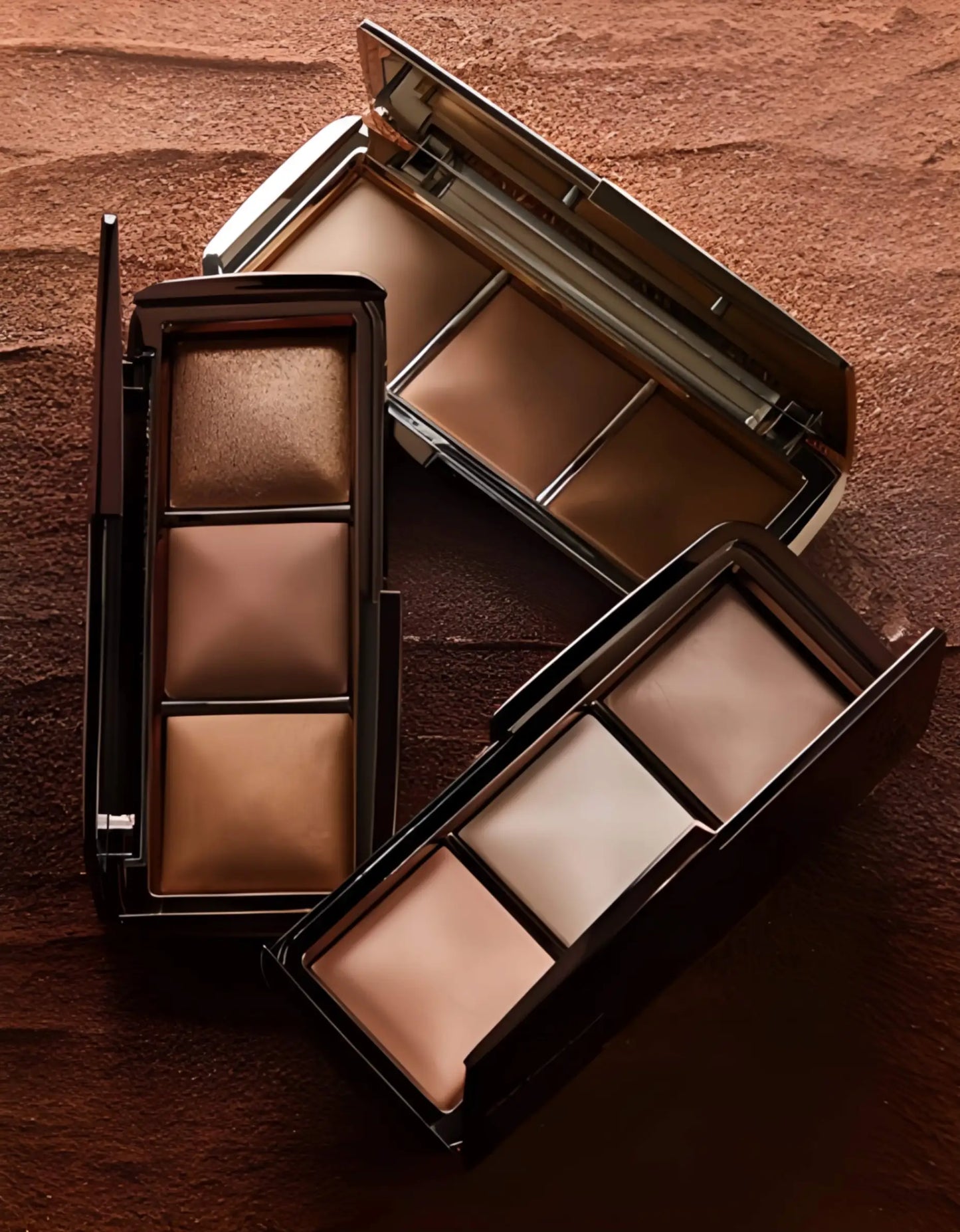 he Hourglass Essentials Set open on a marble surface, showcasing the Ambient Lighting Palette, Unlocked Mascara, and vegan leather bag for a ritual of radiant elegance.