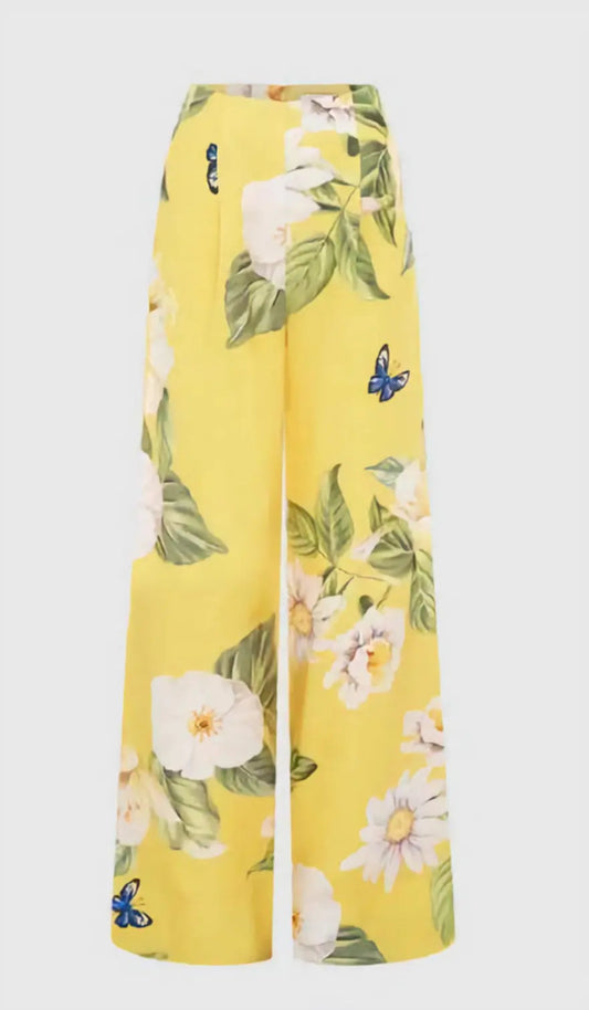 The Luisa Pants in vibrant canary yellow with hand-painted daisy and camellia print, showcasing the wide-leg silhouette and high banded waist.