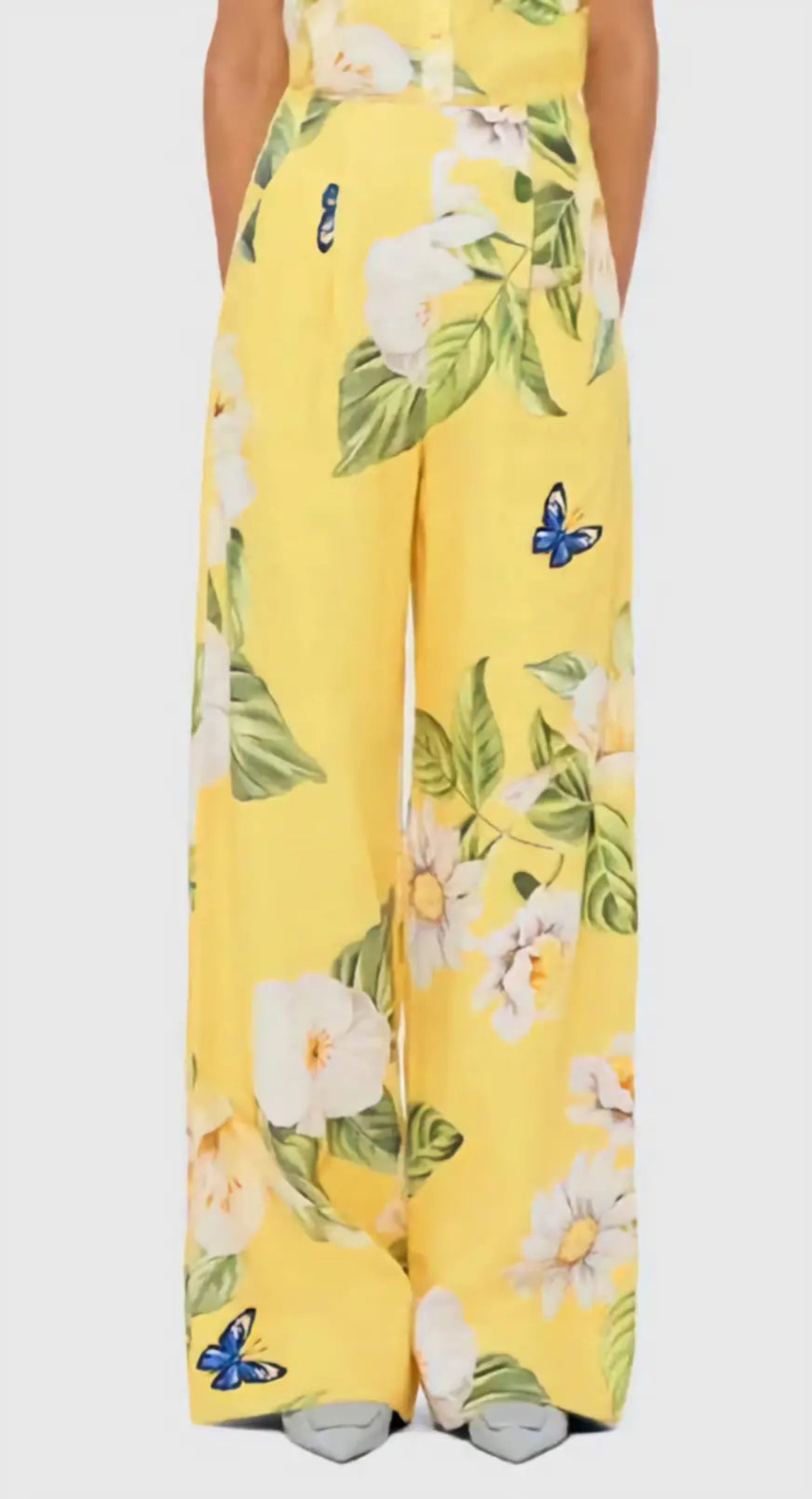 Yellow floral pants with white flowers and green leaves on a white background