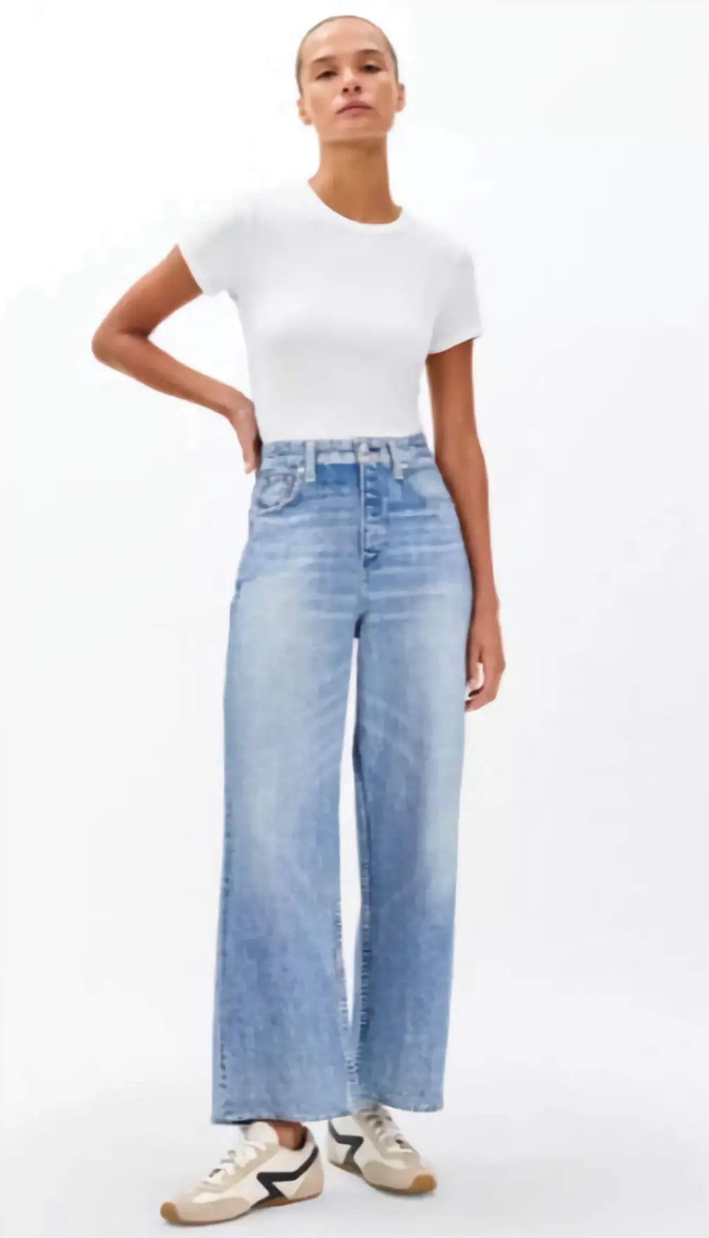 Person wearing a white t-shirt and light blue jeans on a white background
