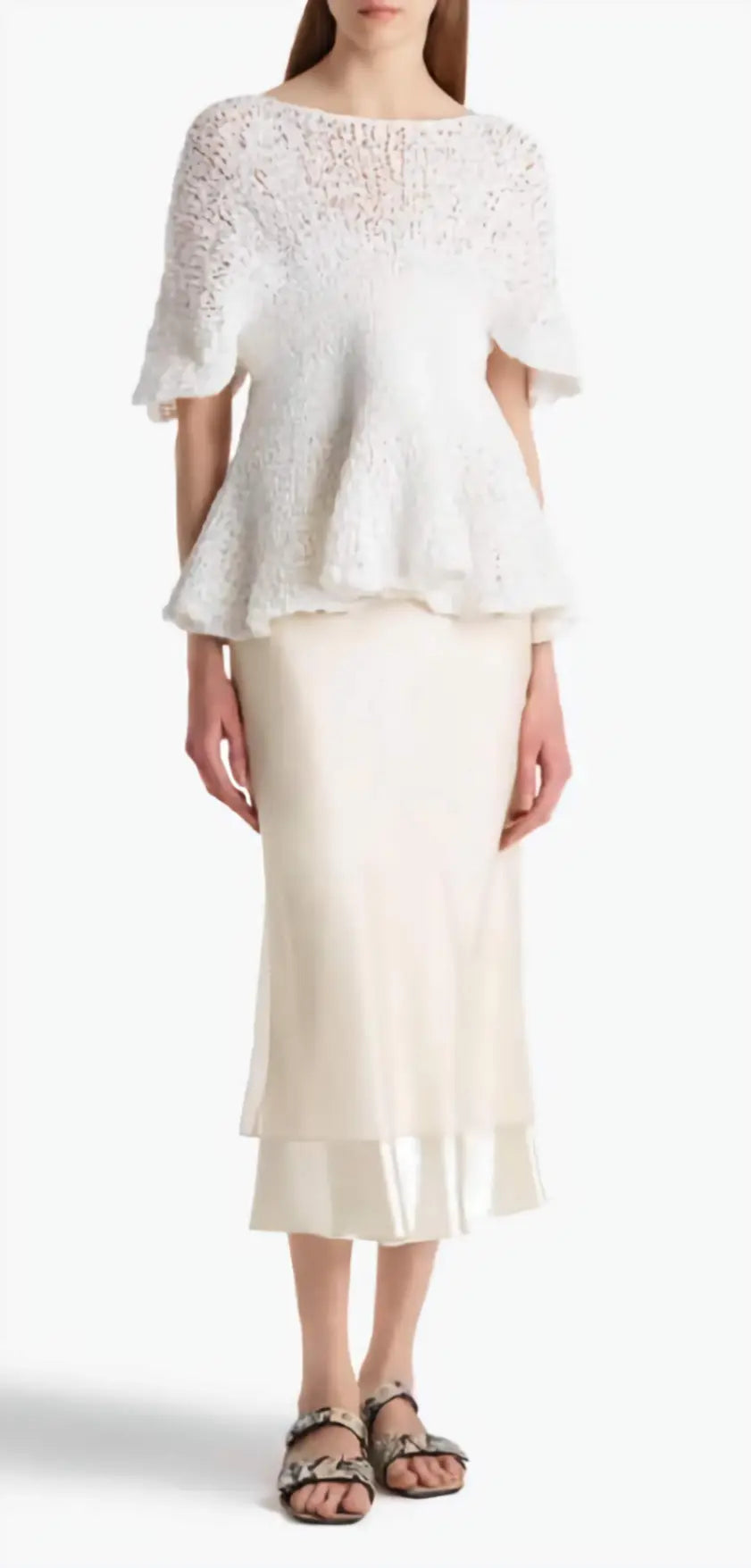 Woman wearing a white lace top and skirt set on a white background