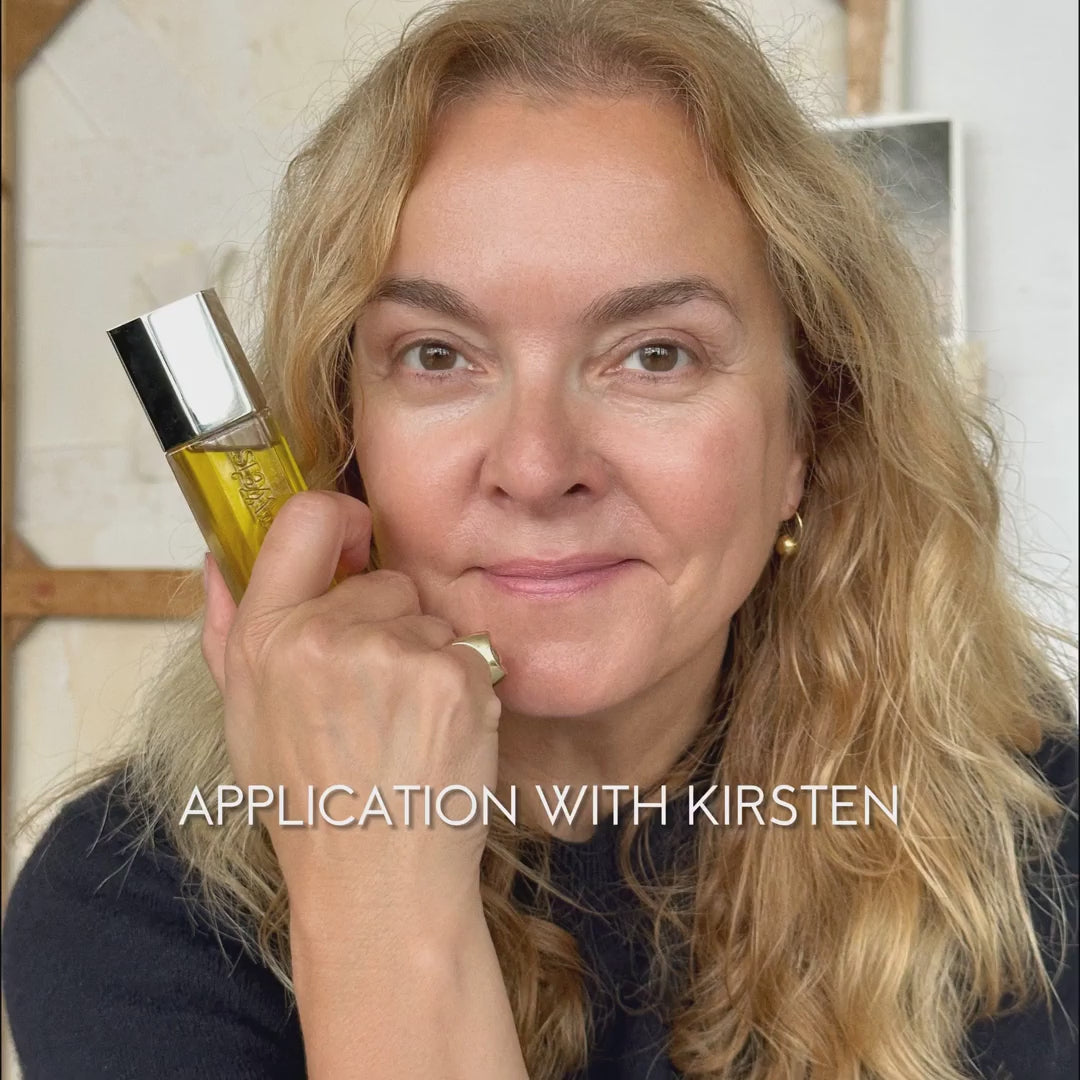 The Beautiful Oil in its iconic Kjaer Weis packaging, with a drop of the golden elixir on skin, showcasing its dewy, non-greasy finish