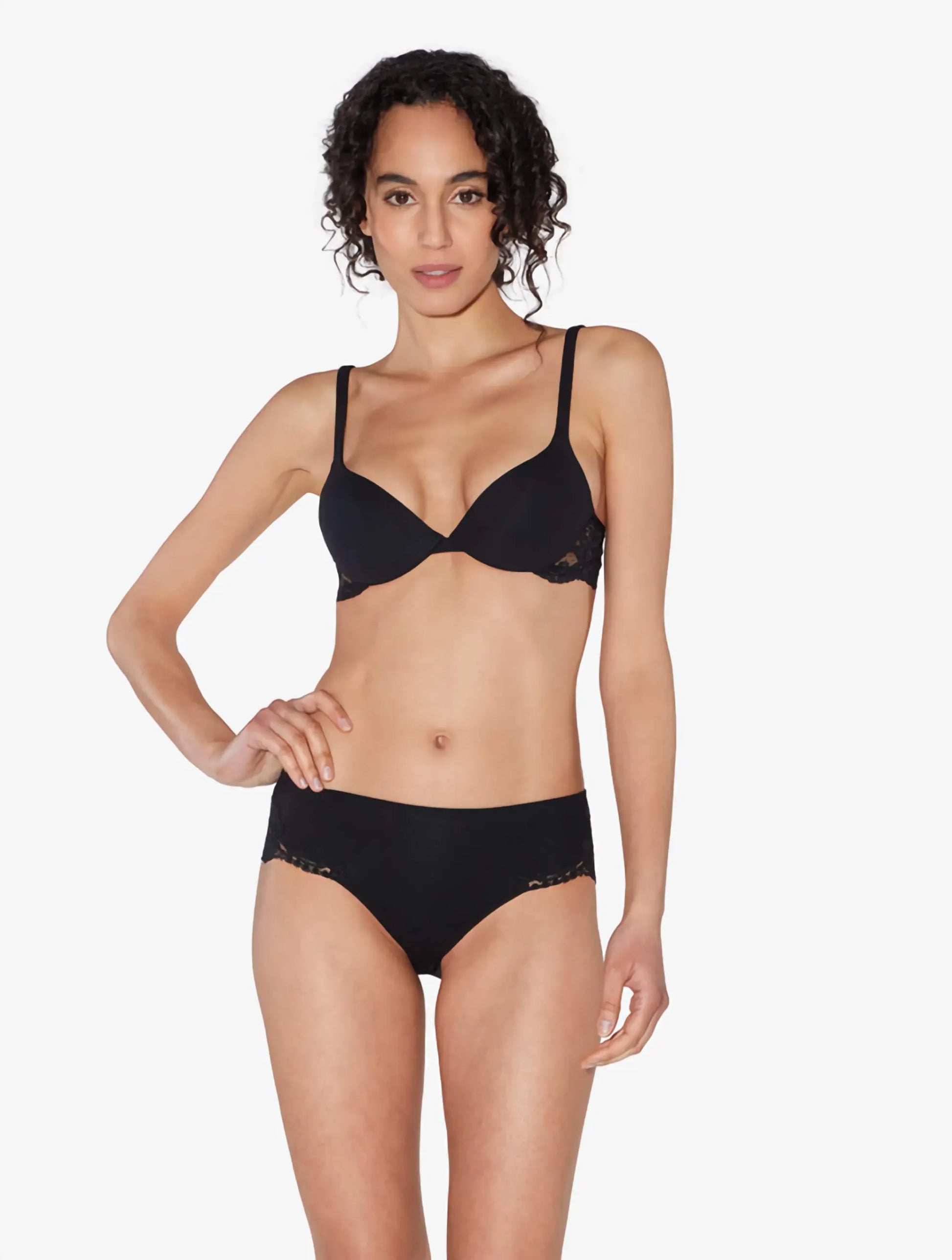 Woman wearing a black bra and panties set on a white background