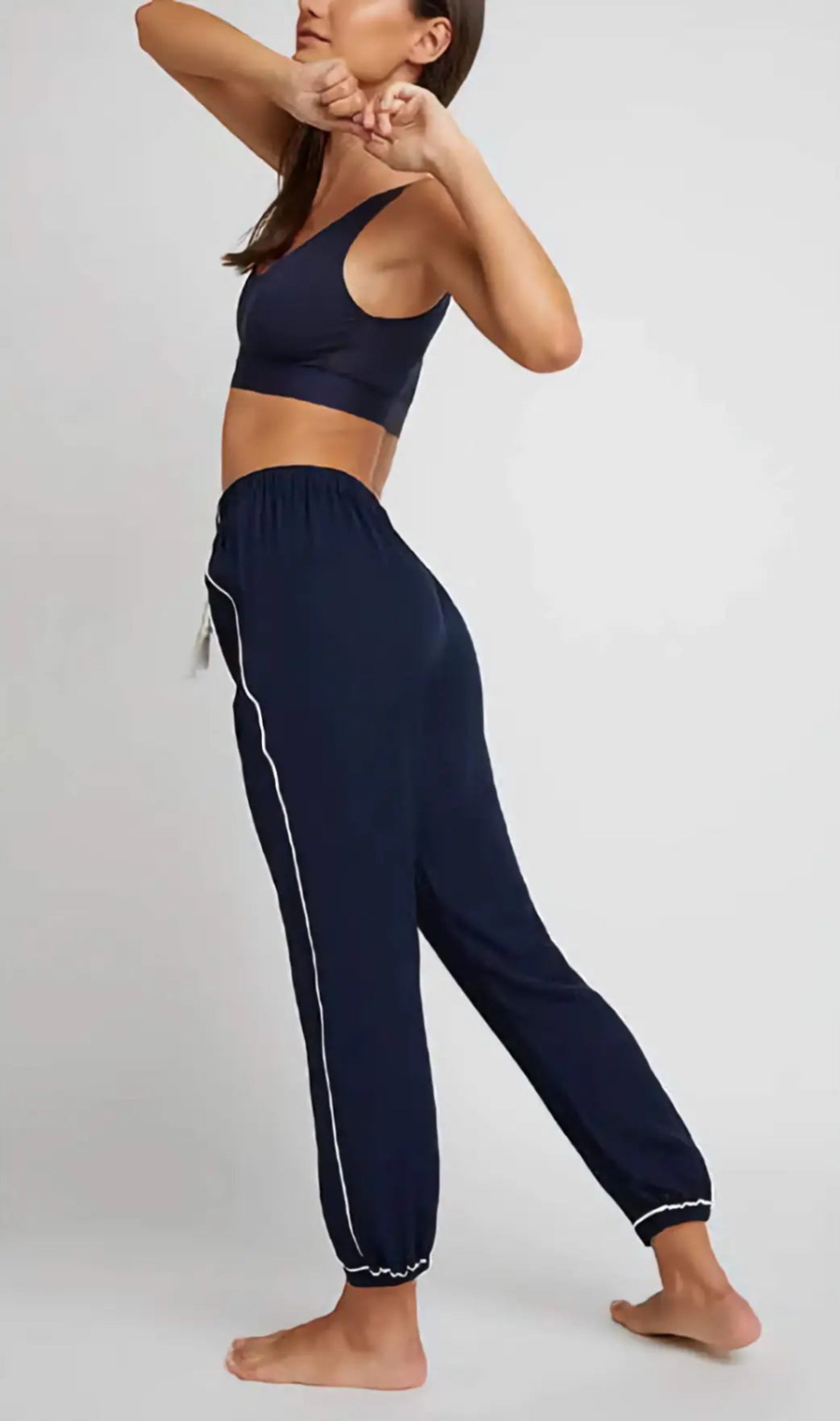 Person wearing navy blue athletic outfit with white trim on a plain background