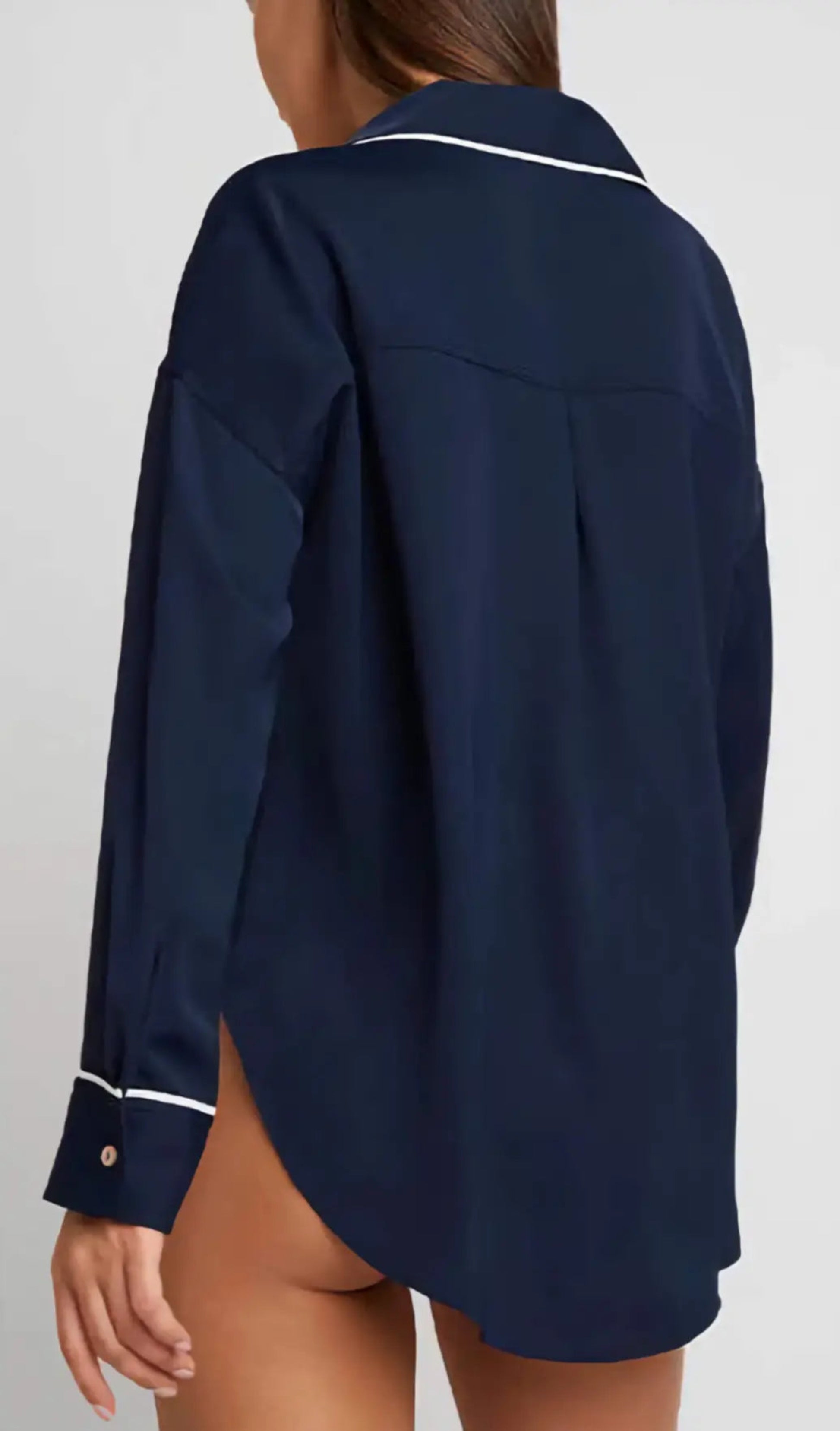 Navy blue shirt with white trim on a plain background