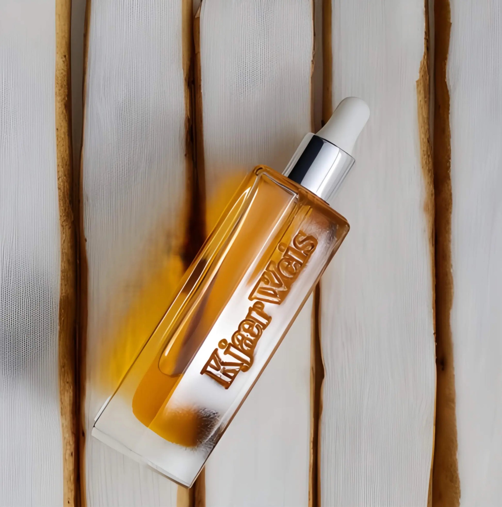 The Beautiful Oil in its iconic Kjaer Weis packaging, with a drop of the golden elixir on skin, showcasing its dewy, non-greasy finish
