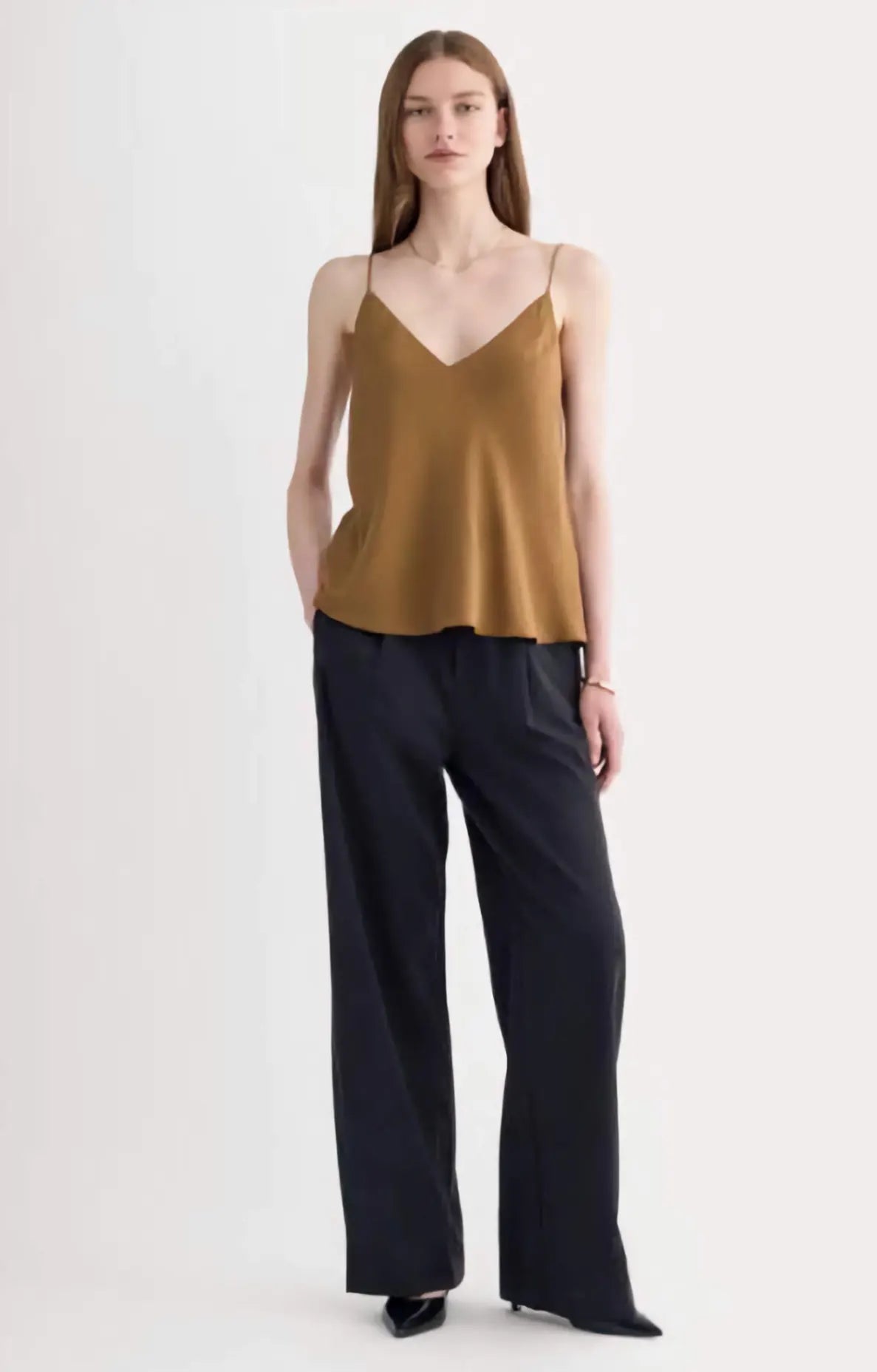 The Tie Back Cami in black clean silk, showcasing the adjustable tie-back and fluid drape on a model, emphasizing its sustainable elegance