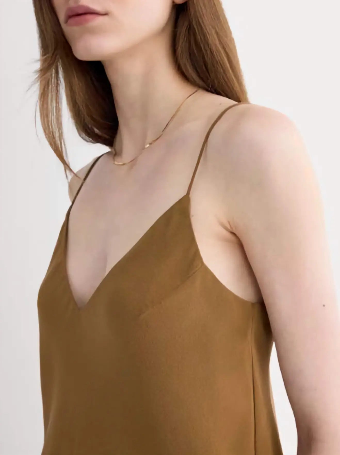 The Tie Back Cami in black clean silk, showcasing the adjustable tie-back and fluid drape on a model, emphasizing its sustainable elegance