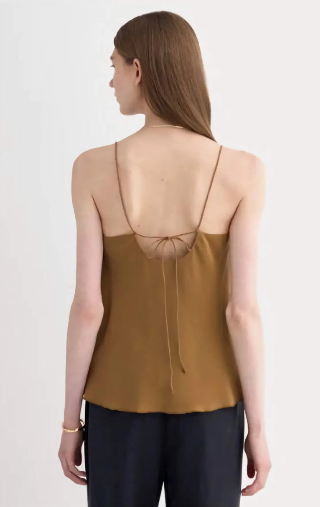 The Tie Back Cami in black clean silk, showcasing the adjustable tie-back and fluid drape on a model, emphasizing its sustainable elegance