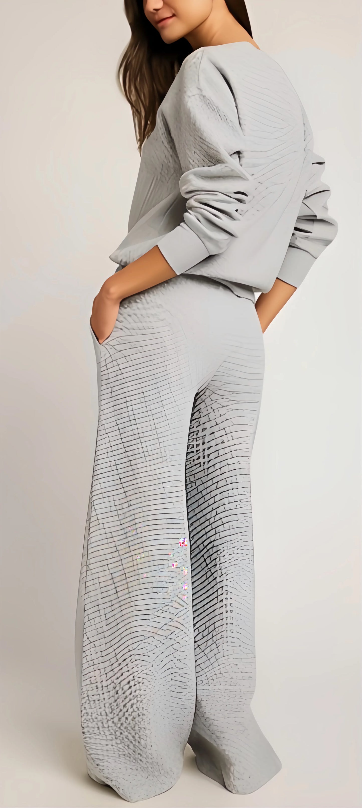 Person wearing a light gray knit outfit on a plain background
